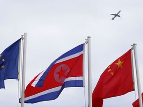A North Korean flag flies with other flags of the ASEAN countries and its dialogue partners outside the Philippine International Convention Center, the venue for the Aug.2-8, 2017 50th ASEAN Foreign Ministers' Meeting, as a passenger plane flies above Thursday, Aug. 3, 2017 in Manila, Philippines. A North Korean flag, center, flies with other flags of ASEAN, Association of Southeast Asian Nations, countries and its dialogue partners outside the Philippine International Convention Center, the venue for the Aug.2-8, 2017 50th ASEAN Foreign Ministers' Meeting, as a passenger plane flies above Thursday, Aug. 3, 2017, in Manila, Philippines. Washington is seeking talks on how North Korea can be suspended from Asia's biggest security forum as part of a broader effort to isolate Pyongyang diplomatically and force it to end its missile tests and abandon its nuclear weapons program, U.S. and Philippine officials said. (AP Photo/Bullit Marquez)