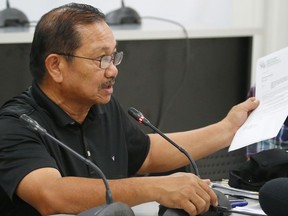 Department of Agriculture Secretary Emmanuel Pinol holds documents during a news conference on the confirmation of the first bird flu case in the country Friday, Aug. 11, 2017 in Manila, Philippines. Pinol said the Philippines will cull at least 400,000 birds after confirming its first bird flu outbreak, but that no animal-to-human transmission has been reported. (AP Photo/Bullit Marquez)