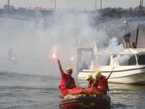 People burn flares on boats on the Vistula river to commemorate the 73st anniversary of the 1944 Warsaw Uprising in Warsaw, Poland,Tuesday, Aug. 1, 2017. Thousands of residents opened an uneven struggle on Aug. 1, 1944 in an effort to liberate the city from the Nazis and take control ahead of the advancing Soviet Red Army. (AP Photo/Czarek Sokolowski)