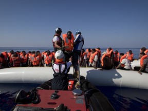 Rescuers transfer African migrants to a rescue boat during a rescue operation from the Aquarius vessel of SOS Mediterranee NGO and MSF (Doctors Without Borders) in the sea some 25 Nautical miles (29 miles, 46 kilometers) north of the Libyan coast, Sunday, Aug. 27, 2017. (AP Photo/Darko Bandic)