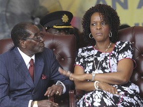 FILE - In this Saturday Feb. 27, 2016 file photo, Zimbabwe President Robert Mugabe, left, and his wife Grace attend his birthday celebrations in Masvingo, Zimbabwe. President Robert Mugabe is in South Africa as his wife is accused of assaulting a young model. (AP Photo/Tsvangirayi Mukwazhi, File)