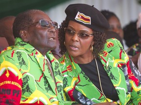 FILE -- In this June, 2, 2017 file photo Zimbabwean President Robert Mugabe, left, and his wife Grace follow proceedings during a youth rally in Marondera Zimbabwe. Mugabe is in South Africa as his wife is accused of assaulting a young model. (AP Photo/Tsvangirayi Mukwazhi, File)