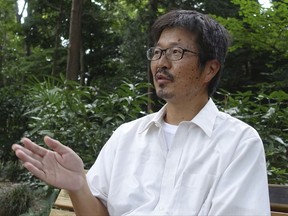 Yoshihisa Tanaka, 53, an animator, says he feels the sense of crisis has been hyped up over North Korea's missile capabilities in an interview as he waited for his family to join him at a Tokyo park Tuesday, Aug. 29, 2017, following the North's latest launch that flew over Japan's northernmost main island of Hokkaido. The launch of a North Korean missile over Japanese territory heightened concern in Japan. But Tokyo residents were fatalistic in response, saying there is little they can do except hope that global leaders resolve the tension peacefully. (AP Photo/Mari Yamaguchi)