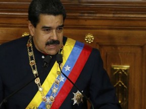 Venezuela's President Nicolas Maduro addresses Constitutional Assembly members at the National Assembly building in Caracas, Venezuela, Thursday, Aug. 10, 2017, as a book at his right shows the face of his late predecessor Hugo Chavez, which outlines Chavez's project coined "Plan de Patria," or "Plan Homeland." Maduro pushed for the creation of the constitutional assembly to rewrite the constitution.  (AP Photo/Ariana Cubillos)