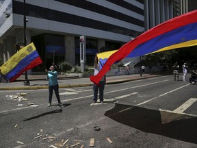 Anti-government demonstrators wave Venezuelan national flags during a protest against Venezuela's President Nicolas Maduro in Caracas, Venezuela, Tuesday, Aug. 8, 2017. The U.S. State Department is repeating its rejection of the new government-loaded assembly rewriting Venezuela's constitution, saying it's "an illegitimate product of a flawed process designed by a dictator." (AP Photo/Wil Riera)