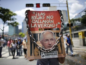 Anti-government demonstrators holds a poster that reads in Spanish "The jails won't shut the truth" and the image of opposition leader arrested Antonio Ledezma during a protest against Venezuela's President Nicolas Maduro in Caracas, Venezuela, Saturday, Aug. 12, 2017. Opposition members called a demonstration to protest the seating of a special assembly to rewrite the constitution. Observers will be closely watching the turnout as the arrest of several mayors and the opposition's decision to compete in regional elections despite concerns the election for the constitutional assembly was marred by fraud. (AP Photo/Ariana Cubillos)
