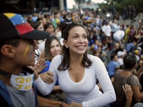 Opposition leader Maria Corina Machado, a former lawmaker, greets supporters during a vigil in honor of those who have been killed during clashes between security forces and demonstrators in Caracas, Venezuela, Monday, July 31, 2017. Many analysts believe Sunday's vote for a newly elected assembly that will rewrite Venezuela's constitution will catalyze yet more disturbances in a country that has seen four months of street protests in which at least 125 people have died. (AP Photo/Ariana Cubillos)