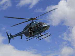 A helicopter carrying a member of the secret police flies over the Paramacay military base in Valencia, Venezuela, Sunday, Aug. 6, 2017. According to the government earlier in the day, troops quickly put down an attack at the army base on Sunday, clashing with a group that said it was out to "re-establish the constitutional order" but was dismissed by officials as a band of civilians working with a deserted lieutenant and a former officer. (AP Photo/Juan Carlos Hernandez)