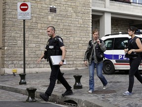 French police officers work on the scene where French soldiers were hit and injured by a vehicle in the western Paris suburb of Levallois-Perret near Paris, France, Wednesday, Aug. 9, 2017. French police are searching for a driver who slammed his BMW into a group of soldiers, injuring six of them in an apparent ambush before speeding away, officials said. The incident in Levallois, northwest of Paris, is the latest of several attacks targeting security forces in France.(AP Photo/Kamil Zihnioglu)