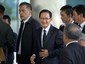 Thailand's former Prime Minister Somchai Wongsawat, center, smilies upon his arrival at a courthouse Wednesday, Aug. 2, 2017, in Bangkok, Thailand. A Thai court is scheduled to deliver the verdict on criminal charges against Somchai and his former deputy Chavalit Yongchaiyudh for the deadly dispersal of anti-government protesters blocking Parliament in 2008. (AP Photo/Gemunu Amarasinghe)