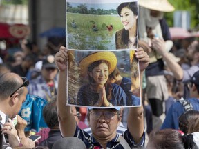 Supporters of Thailand's former Prime Minister Yingluck Shinawatra display her images outside the Supreme Court after Yingluck failed to show up to hear a verdict in Bangkok, Thailand, Friday, Aug. 25, 2017. Thailand's military ruler said authorities are searching for Yingluck Shinawatra, the prime minister whose government he ousted in a coup three years ago, after she failed to appear for a verdict Friday in a criminal case that could send her to prison for 10 years. (AP Photo/Gemunu Amarasinghe)