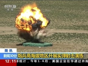 In this image taken from a recent video footage run by China's CCTV on Friday, Aug 4, 2017, a target explodes during a live-fire drill by the Chinese army in China's Tibet Autonomous Region that border India. Beijing is intensifying its warnings to Indian troops to get out of a contested region high in the Himalayas where China, India and Bhutan meet, saying China has been restrained but "restraint has its limits." Chinese characters in yellow reads "Artillery soldiers high altitude live fire drills". (CCTV via AP)
