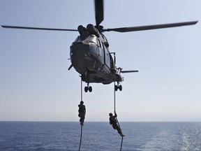 Lebanese army soldiers rappel down from a helicopter onto the deck of the Brazilian warship UNIAO, part of the UNIFIL Maritime force, during a joint training to apprehend the smuggling of illegal material, off the coast of Beirut, Lebanon, Wednesday, Aug. 23, 2017. The head of the U.N. peacekeepers in Lebanon says his force has no evidence that weapons are being illegally transferred in the country's south, rebuffing criticism the mission is failing to stem their spread. (AP Photo/Hussein Malla)