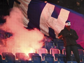 FILE - In this Aug. 14, 2017 file photo, soccer fans set fire to seating in the Ostseestadion stadium during the first round of the German Soccer Cup match between Hansa Rostock and  Hertha BSC Berlin in Rostock, Germany.  Play was suspended twice during the second half of the match due to fireworks set off by both sets of fans. Fan trouble and the threat of violence around games are overshadowing Friday's Aug. 18, 2017  start to the Bundesliga. . (Axel Heimken/dpa via AP.file)