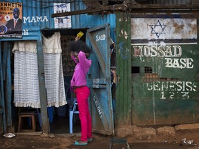 A Kenyan girl brushes her hair in the Kibera slum in Nairobi, Kenya, Monday, Aug. 7, 2017. Kenyans are due to go to the polls on Aug. 8. to vote in a general election after a tightly-fought presidential race between President Uhuru Kenyatta and main opposition leader Raila Odinga. (AP Photo/Jerome Delay)