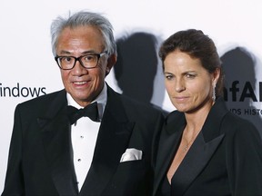 In this Saturday, March 14, 2015, photo, Hong Kong businessman and socialite David Tang, left, poses with his wife Lucy on the red carpet for the fundraising gala organized by amfAR (The Foundation for AIDS Research) in Hong Kong. Tang, a flamboyant and outspoken socialite and entrepreneur who founded the Shanghai Tang fashion brand, has died. He was 63. (AP Photo/Kin Cheung)