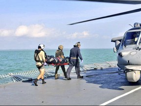 transferred to a U.S. Navy helicopter off the Johor coast of Malaysia, Wednesday, Aug. 23, 2017. The commander of the Navy's 7th Fleet will be removed after a series of warship accidents in the Pacific this year, two U.S. officials said Wednesday. (Royal Malaysian Navy via AP)