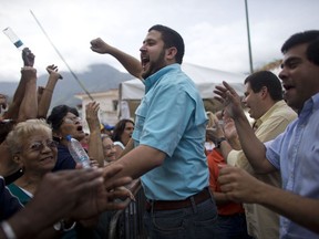 FILE - In this June 24, 2016 file photo, David Smolansky, mayor of El Hatillo district, center, shouts with others standing in line, after learning the validation center to certify the authenticity of petitioners' signatures has closed without attending them, in Caracas, Venezuela. The government-packed Supreme Court on Wednesday, Aug. 9, 2017, ordered the removal and imprisonment for 15 months of the Caracas-area for not obeying orders to shut down protests in his district. (AP Photo/Ariana Cubillos, File)