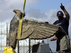 FILE- In this Feb. 10, 2006 file photo, an Uruguayan worker directs the salvage the eagle of World War II German pocket battleship Admiral Graf Spee, in Montevideo, Uruguay. A symbol of German naval might in early World War II, was sunk in Dec. 1939. The Uruguayan government has called on all political parties on Wednesday, August 16 2107, to decide what to do with the eagle. (AP Photo/Marcelo Hernandez, File)