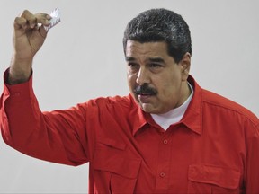 FILE - In this July 30, 2017 file photo, released by the Miraflores Press Office, Venezuela's President Nicolas Maduro shows his ballot after casting a vote for a constitutional assembly in Caracas, Venezuela. With the installation on Friday, Aug. 4, of Venezuela's newly elected, all-powerful constituent assembly, President Maduro's foes fear the body that will write a new constitution is going to entrench the socialist administration and create a one-party state.(Miraflores Press Office via AP, File)