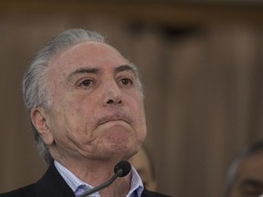 Brazil's president Michel Temer speaks to the press during his visit to the operations control center at the Army's headquarters in Rio de Janeiro, Brazil, Sunday, July. 30, 2017. Thousands of soldiers began patrolling Rio de Janeiro amid a spike in violence in Brazil's second-largest city. (AP Photo/Leo Correa)