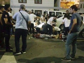 EDS NOTE: GRAPHIC CONTENT - In this image made from video, police gather at the scene of an attack in Istanbul, late Sunday, Aug. 13, 2017. Turkey's official news agency says a man suspected of being a suicide bomber for the Islamic State group has stabbed and killed a police officer while in custody. Anadolu Agency reported that police detained a man thought to be planning a bomb attack on behalf of IS. The suspect was taken to Istanbul police headquarters, where police say he attacked an officer with a knife. The officer died. The man was shot and killed in the attack. (DHA/Depo photos via AP)