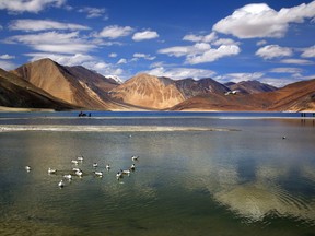 In this Sunday, June 17, 2016, photo, an Indian tourist rides on a horse back at the Pangong lake high up in Ladahak region of India. The Chinese soldiers hurled stones while attempting to enter Ladakh region near Pangong Lake on Tuesday but were confronted by Indian soldiers, said a top police officer. The officer said Indian soldiers retaliated but neither side used guns. There was immediately no comment from China. (AP Photo/Manish Swarup)