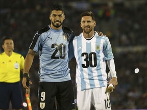 Argentina's Lionel Messi and Uruguay's Luis Suarez pose for pictures wearing the number 20 and 30 as the support the candidacy of Uruguay and Argentina for the 2030 World Cup before a 2018 World Cup qualifying soccer match in Montevideo, Uruguay, Thursday, Aug. 31, 2017.(AP Photo/Natacha Pisarenko)