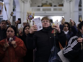 Devotees attend a Mass marking the feast day of San Cayetano or Saint Cajetan, at a church named in his honor, in Buenos Aires, Argentina, Monday, Aug. 7, 2017. Known as the patron saint of the unemployed, thousands of Catholics visit the church on the Italian saint's feast day to pray for prosperity and employment. (AP Photo/Natacha Pisarenko)
