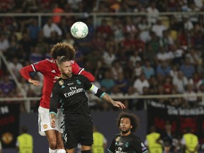 Manchester United's Marouane Fellaini ,and Real Madrid's Sergio Ramos, front, challenge for a header during the UEFA Super Cup final soccer match between Real Madrid and Manchester United at Philip II Arena in Skopje, Tuesday, Aug. 8, 2017. (AP Photo/Boris Grdanoski)
