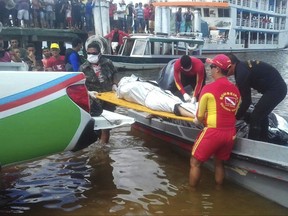 In this photo released by Brazil's Secretary of Social Communication, rescue workers carry a body recovered from the Xingu River, in Porto de Moz, in Para state, Brazil, Thursday, Aug. 24, 2017, during a search mission for the passengers of the "Comandante Ribeiro" that sank on late Tuesday. The public security office of the state of Para said 15 people made it to the shore and at least 19 bodies were recovered, while the rest were unaccounted for. Earlier the office had reported that 25 reached the shore. Authorities said the boat was traveling on the Xingu River when it sank. The cause was not immediately clear. (SECOM photo/Marcio Flexa via AP)