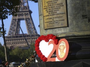 Photographs and flowers are placed by people in memory of the late Princess Diana above the Pont de l'Alma tunnel in Paris, Thursday, Aug. 31, 2017. The Princess of Wales died in a car crash in the tunnel on Aug. 31, 1997. Thursday marks the 20th anniversary of her death. (AP Photo/Thibault Camus)