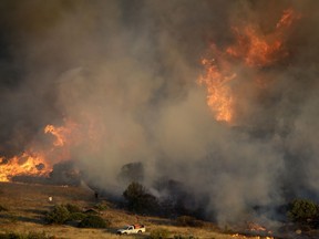 Firefighters try to extinguish a fire in the Kalyvia area some 30 kilometers (18 miles) south of Athens, Monday, July 31, 2017. Dozens of firefighters, assisted by five water-dropping helicopters, are battling a large brush fire south of Athens, but Greek authorities say no inhabited areas are in immediate danger. (AP Photo/Thanassis Stavrakis)