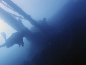 In this Tuesday, July 18, 2017 photo, a diver swims under part of the Italian World War II shipwreck MV Probitas in Saranda Bay, southern Albania. On the seabed off the rugged shores of Albania, one of the world's least explored underwater coastlines, lies a wealth of treasures. Ancient amphorae that carried olive oil and wine; wrecks with hidden tales of heroism and treachery from two world wars; spectacular rock formations and marine life. (AP Photo/Elena Becatoros)