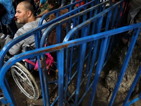 A disabled man sits in his wheelchair while taking part in a protest outside the Labour Ministry in Bucharest, Romania, Tuesday, Aug. 22, 2017. Hundreds of disabled people joined the protest to express their anger at a government emergency decree that changes the current law and no longer obliges companies with more than 50 employees to hire a number of disabled people or use the services of a department that hires special needs personnel which could lead to 2,000 disabled people losing their jobs. (AP Photo/Vadim Ghirda)