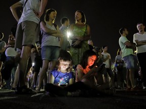 Children's faces are illuminated by mobile phone screens as protesters stand outside the government headquarters in Bucharest, Romania, Sunday, Aug. 27, 2017. According to officials more than 1,000 people have protested in Bucharest and other Romanian cities against a series of proposals presented by Justice Minister Tudorel Toader, that critics say will reverse the anti-corruption fight.(AP Photo/Vadim Ghirda)