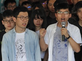 Hong Kong activist Joshua Wong, right, and Nathan Law, left, speak outside the high court before a ruling on a prosecution request for stiffer sentences following a lower court decision that let them avoid prison in Hong Kong, Thursday, Aug. 17, 2017. Young Hong Kong activist Wong and two other student leaders of huge pro-democracy protests in 2014 braced for a court decision Thursday that could send them to prison. The three were found guilty of leading or encouraging an illegal rally in September 2014 that kicked off the demonstrations known as the "Umbrella Movement." (AP Photo/Vincent Yu)