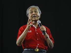 Former Malaysian Prime Minister Mahathir Mohamad speaks during a forum in Shah Alam, Malaysia, Sunday, Aug. 13, 2017. Mahathir who now heads an opposition coalition, was marred by violence, with several people hurling flares, chairs and shoes at the stage. Mahathir, who has set up a new political party to oust Prime Minister Najib Razak in elections due by mid-2018, was answering questions at the forum, hosted by his party, when chaos erupted. (AP Photo/Daniel Chan)