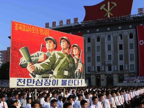 Tens of thousands of North Koreans gathered for a rally at Kim Il Sung Square carrying placards and propaganda slogans as a show of support for their rejection of the United Nations' latest round of sanctions on Wednesday Aug. 9, 2017, in Pyongyang, North Korea. Sign says, "Protect our nation to the death" and "Hearts of 10 million people are burning."