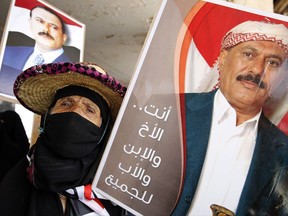 FILE -- In this March 26, 2016 file photo, a supporter of former Yemeni President Ali Abdullah Saleh holds his photo during a rally in Sanaa, Yemen. A long-simmering power struggle between Yemen's Shiite rebels and Saleh has burst into the open, threatening to undermine their alliance against the internationally-recognized government and its Saudi-led backers. In a manifestation of their differences, armed men suspected of links to the rebels on Sunday, Aug. 20, 2017, tore up poster portraits of former president Ali Abdullah Saleh and his son and one-time heir Ahmed in Sanaa, Yemen's capital. (AP Photo/Hani Mohammed, File)