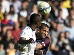 PSG's Dani Alves, right, and Amien's Khaled Adenon challenge for a header during the French League One soccer match between Paris Saint Germain and Amiens at the Parc des Princes stadium in Paris, France, Saturday, Aug. 5, 2017. (AP Photo/Kamil Zihnioglu)