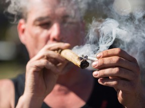 This file photo taken on April 20, 2016 shows a man smoking marijuana as others gather to celebrate National Marijuana Day on Parliament Hill in Ottawa, Canada.