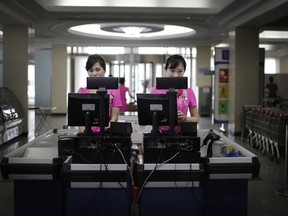 In this Monday, June 19, 2017, photo, cashiers stand at checkout counters waiting to serve customers at the Potonggang department store in Pyongyang, North Korea