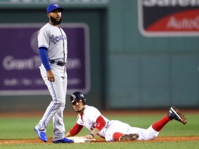 Mookie Betts of the  Red Sox steals second base behind Richard Urena of the Toronto Blue Jays during the first inning of their game Wednesday night at Fenway Park in Boston.