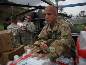 Sergeant Angel Cotton and other members of the Puerto Rican National Guard deliver food and water via helicopter to hurricane survivors as they deal with the aftermath of Hurricane Maria on September 29, 2017 in Lares, Puerto Rico.