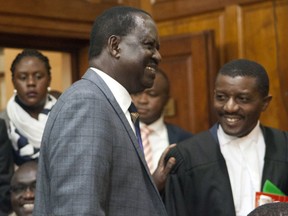 Opposition presidential candidate Raila Odinga, centre, reacts at the Kenya Supreme Court, in Nairobi, Kenya, Friday, Sept. 1, 2017. Kenya's Supreme Court has overturned President Uhuru Kenyatta's re-election dismissing backing a petition by veteran opposition leader Raila Odinga who claimed votes had been manipulated to deny him victory. (AP Photo/Sayyid Abdul Azim)