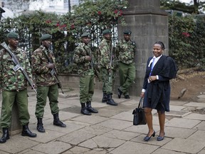 A lawyer arrives past a line of police guarding the building ahead of an expected verdict in the presidential election petition at the Supreme Court in downtown Nairobi, Kenya, Friday, Sept. 1, 2017. Kenya's Supreme Court has been hearing veteran opposition leader Raila Odinga's challenge to President Uhuru Kenyatta's re-election earlier this month. (AP Photo/Ben Curtis)