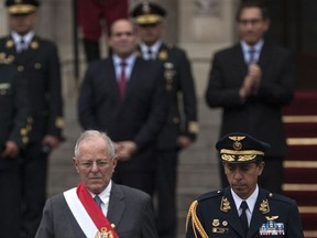 Peru's President, Pedro Pablo Kuczynski, left, walks during a ceremony commemorating 25 years of the capture of Shining Path leader Abimael Guzman, outside the National Palace in Lima, Peru, Tuesday, Sept. 12, 2017. Peru's parliament and President Kuczynski paid a tribute to the police intelligence group, GEIN, that captured Shining Path leader Abimael Guzman, achieving the hardest blow for the Peruvian Maoist movement in 1992. (AP Photo/Rodrigo Abd)