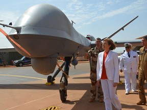This file photo taken on July 31, 2017 shows French Minister of Army Forces Florence Parly, checking out an armed drone. Canada unsuccessfully tried to buy similar unmanned aircraft second-hand.