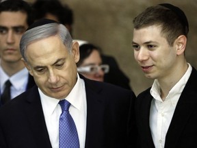 A picture taken on March 18, 2015 shows Israeli Prime Minister Benjamin Netanyahu and his son Yair visiting the Wailing Wall in Jerusalem